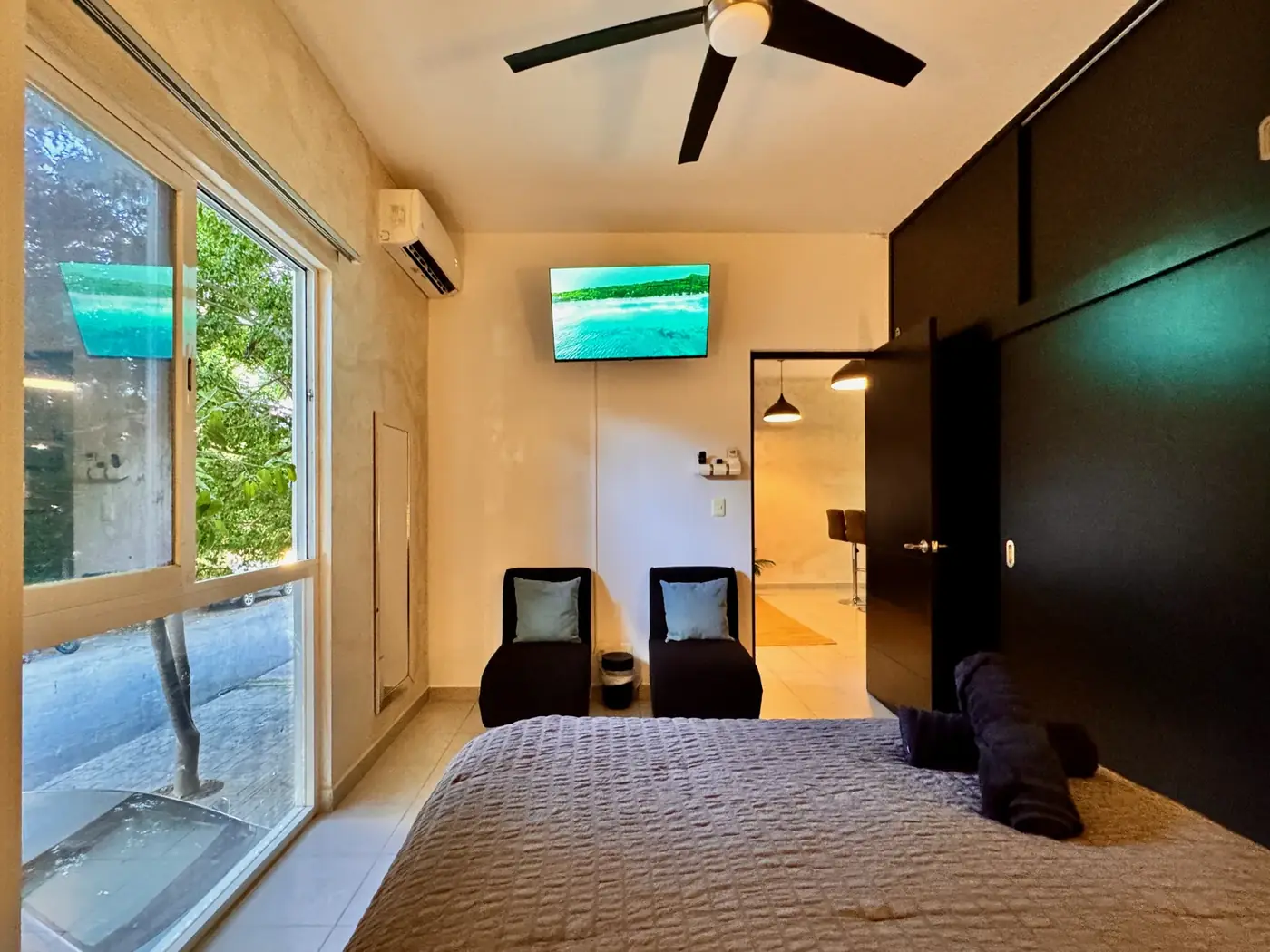 The main bedroom with a large window and air conditioning